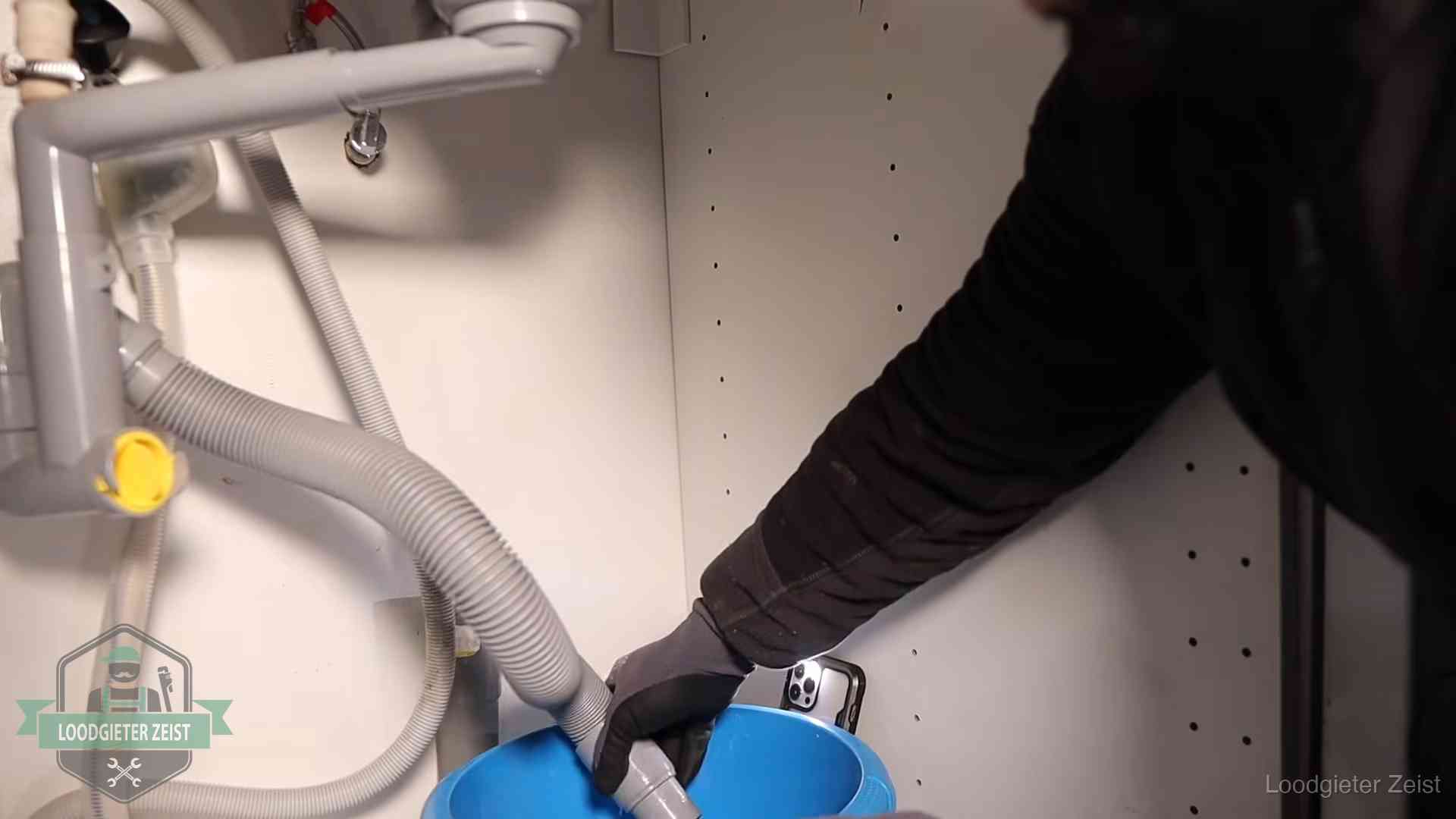 Afvoerslang loopt leeg in een emmer onder de gootsteen in Zeist, een klus die je zelf kunt doen