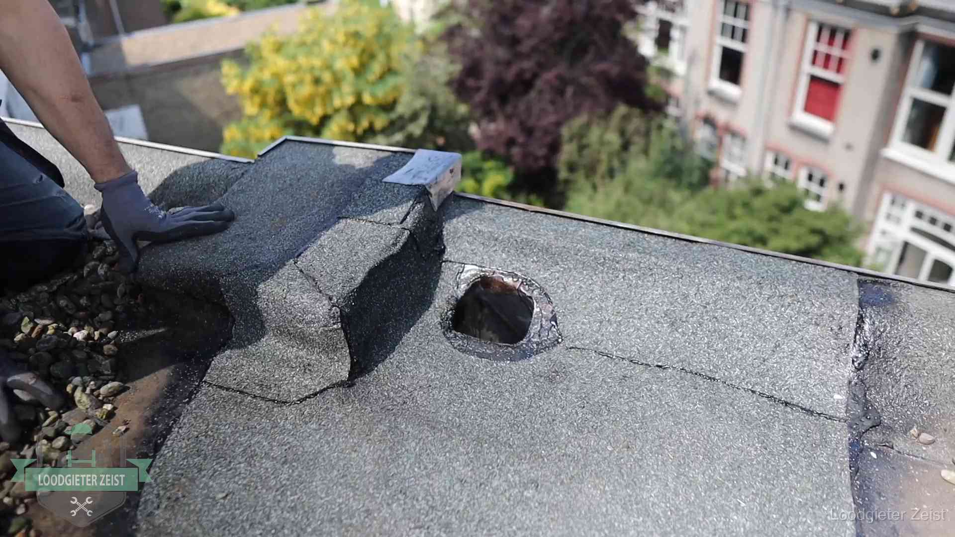 Loodgieter inspecteert een beschadigd bitumen plat dak tijdens een daklekkage-inspectie in Zeist