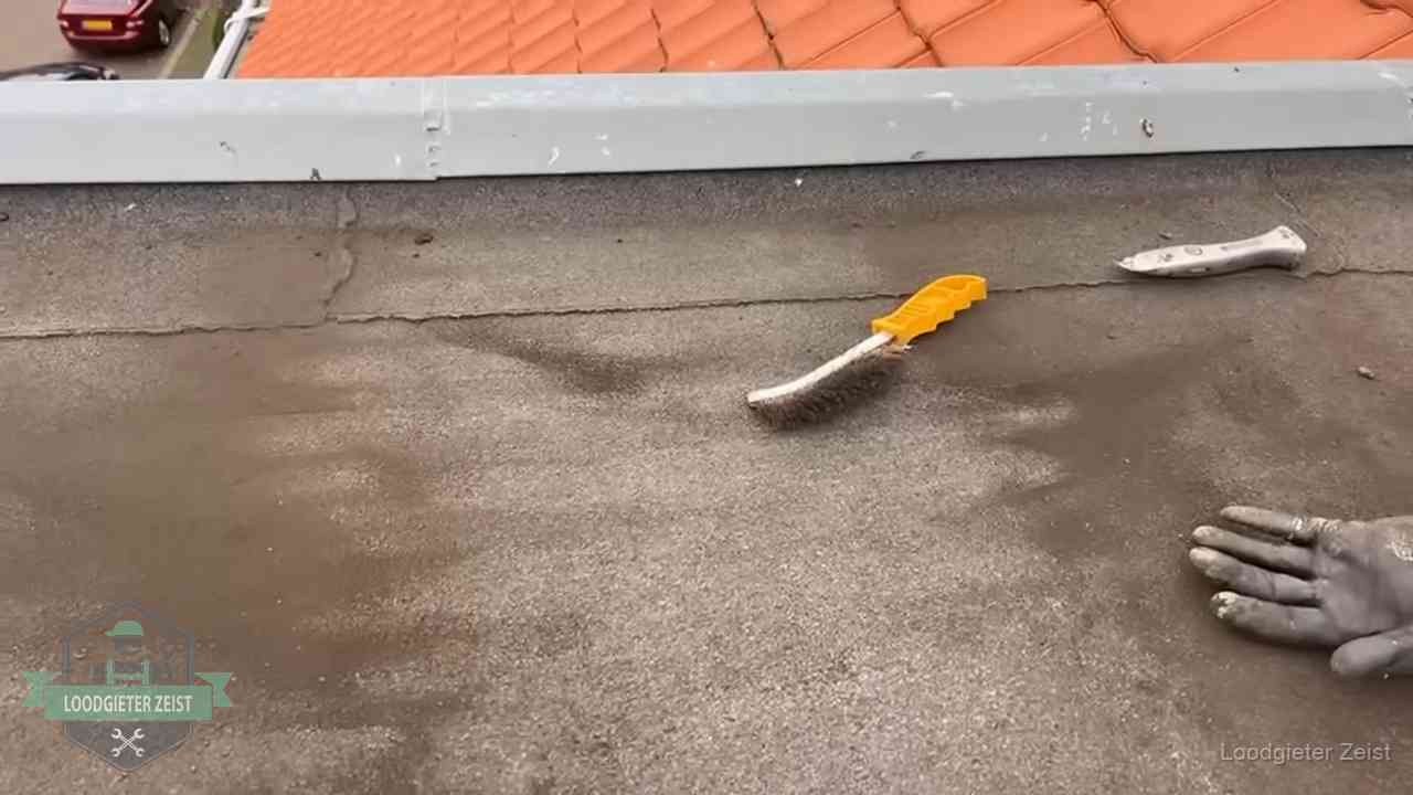 Dakdekker bereidt een bitumen plat dak voor op reparatie bij de daktrim in Zeist
