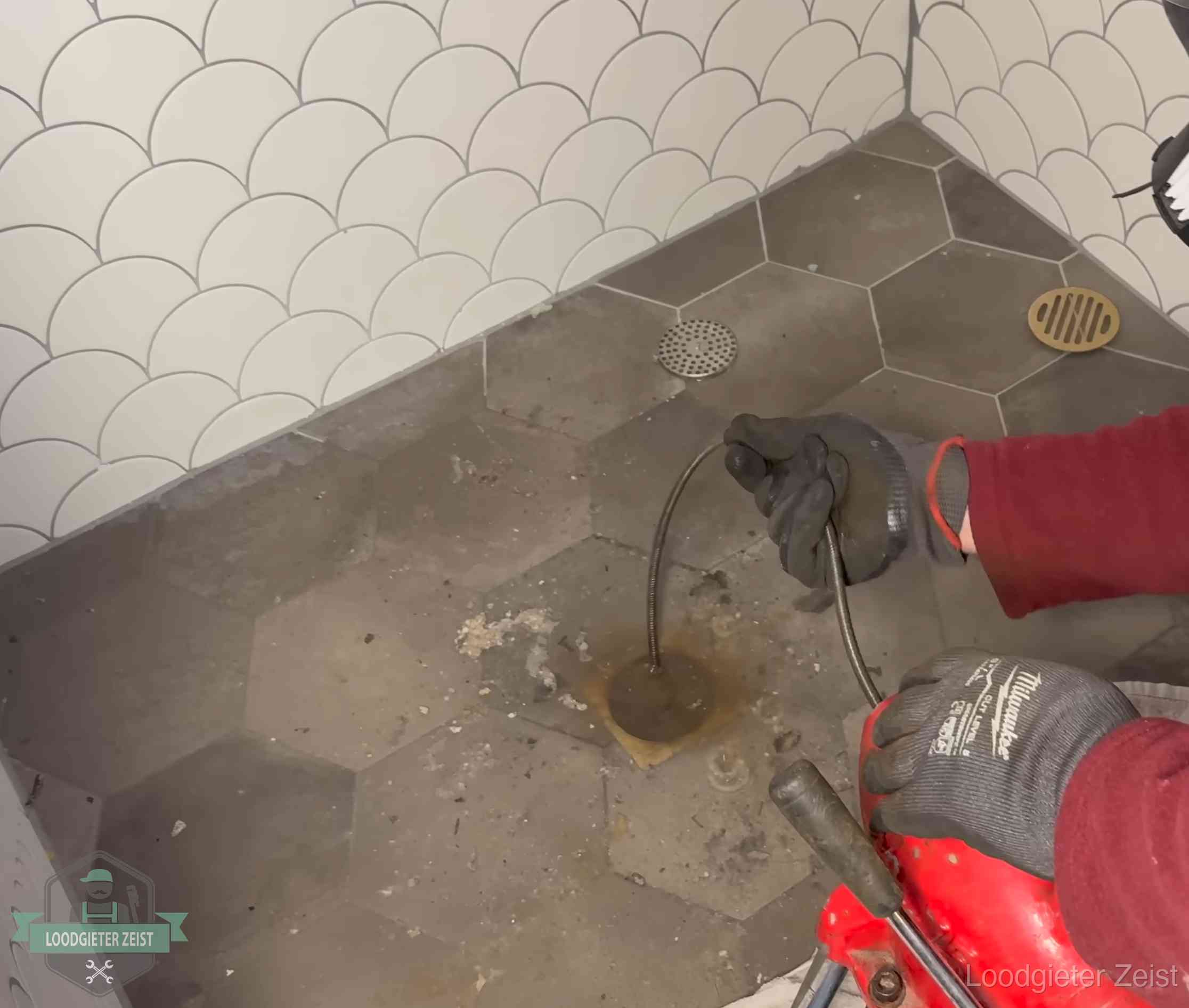 Ontstoppingsveer gaat in een geopend doucheputje in Zeist waar het water omhoogkwam