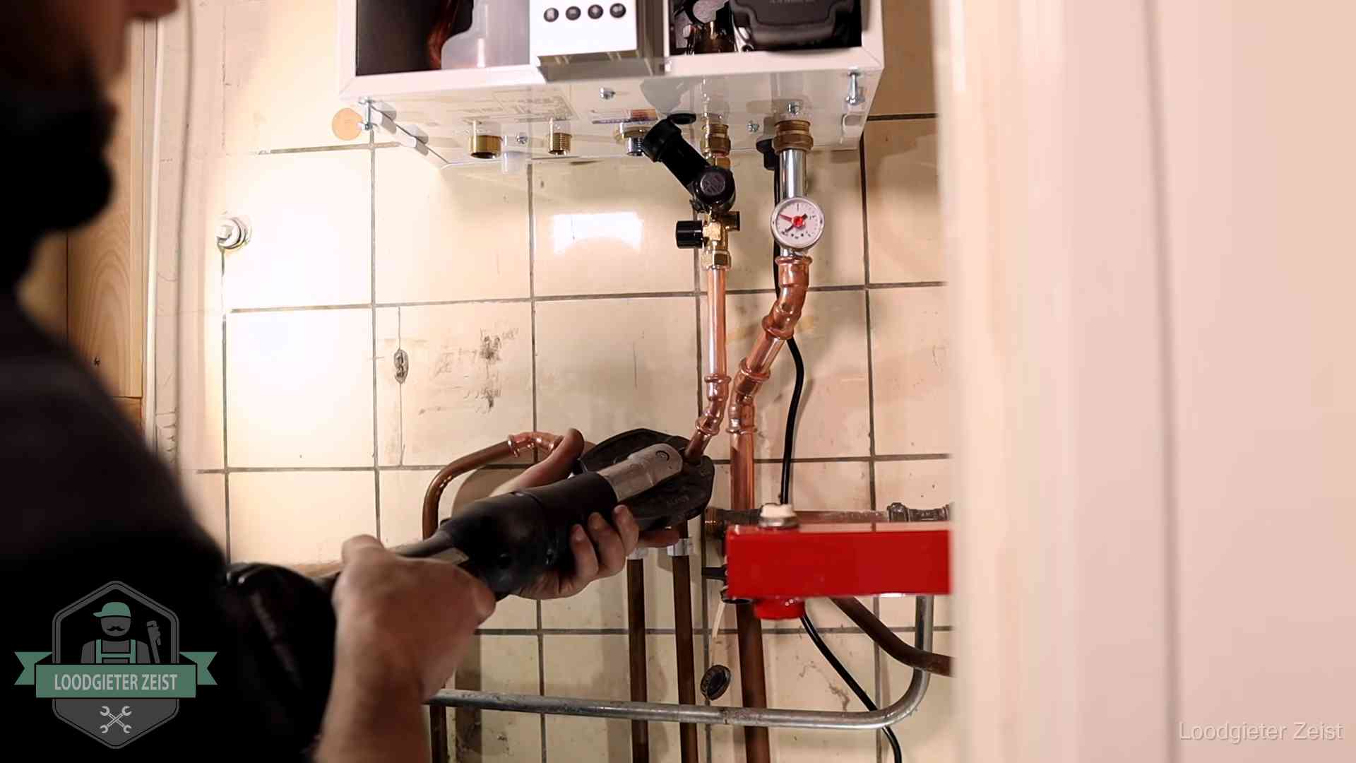 Monteur werkt aan de leidingen onder een cv-ketel in Zeist