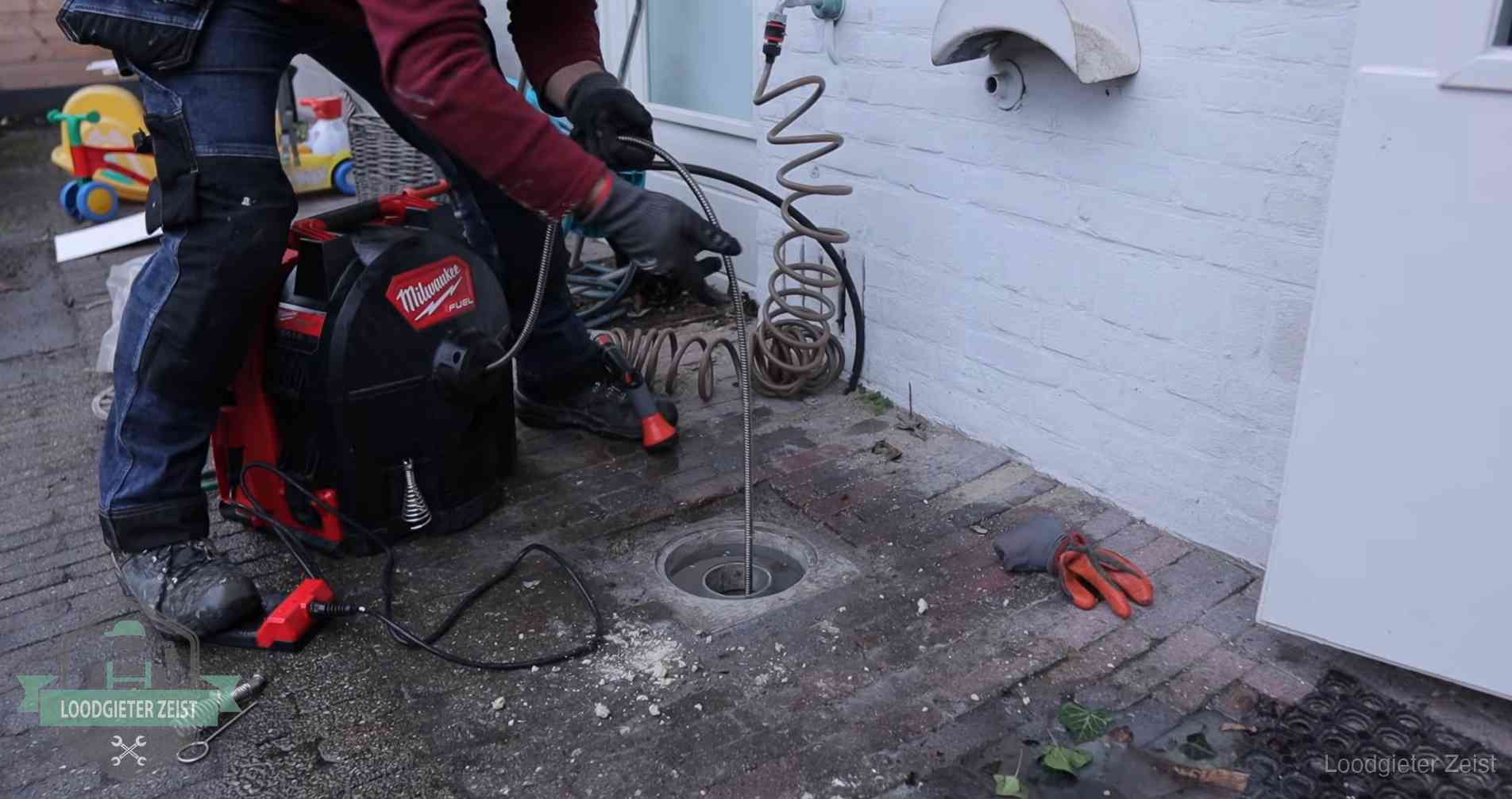 Ontstoppingsputje in de bestrating naast de gevel van een woning in Zeist