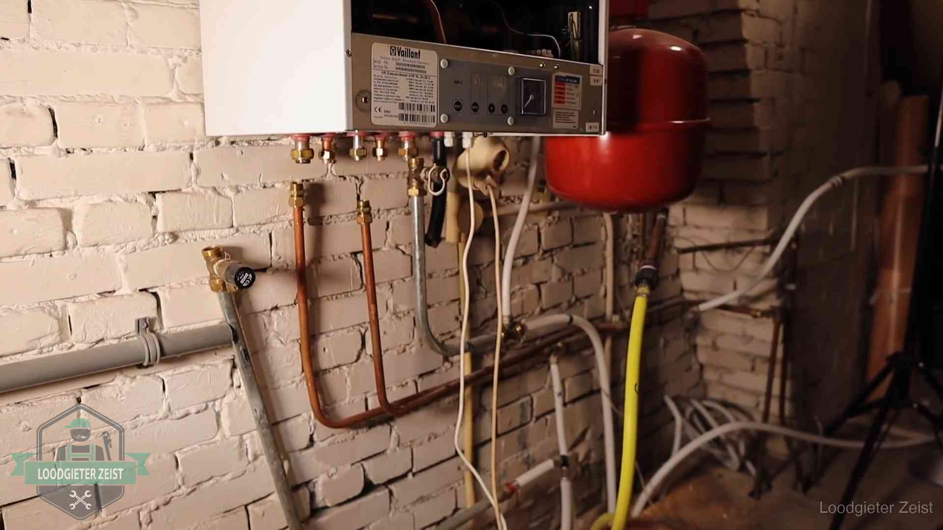 Verouderde cv-ketel met een wirwar van oude leidingen in een woning in Zeist