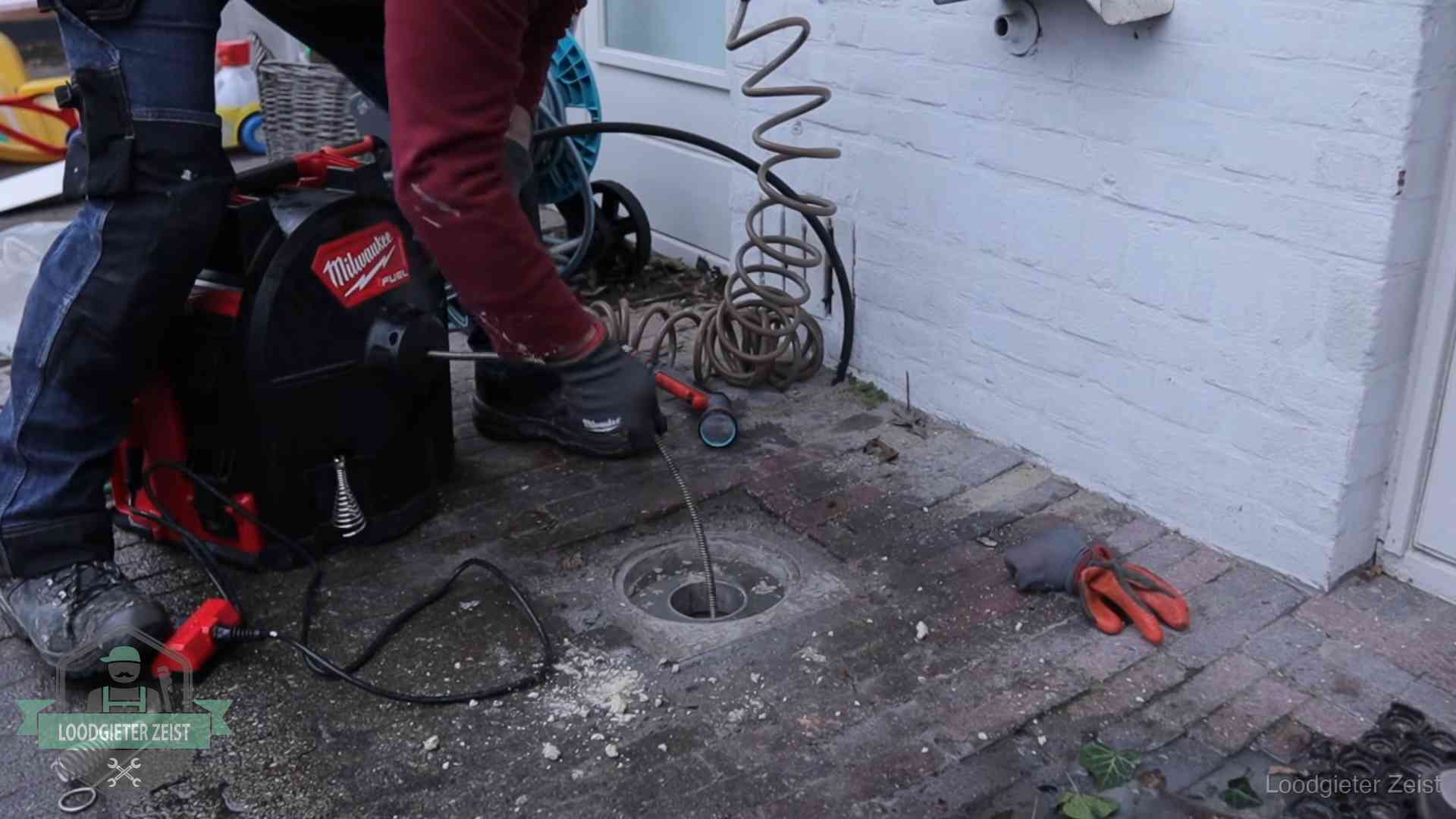 Spiraalmachine bij een ontstoppingsputje in de bestrating in Zeist