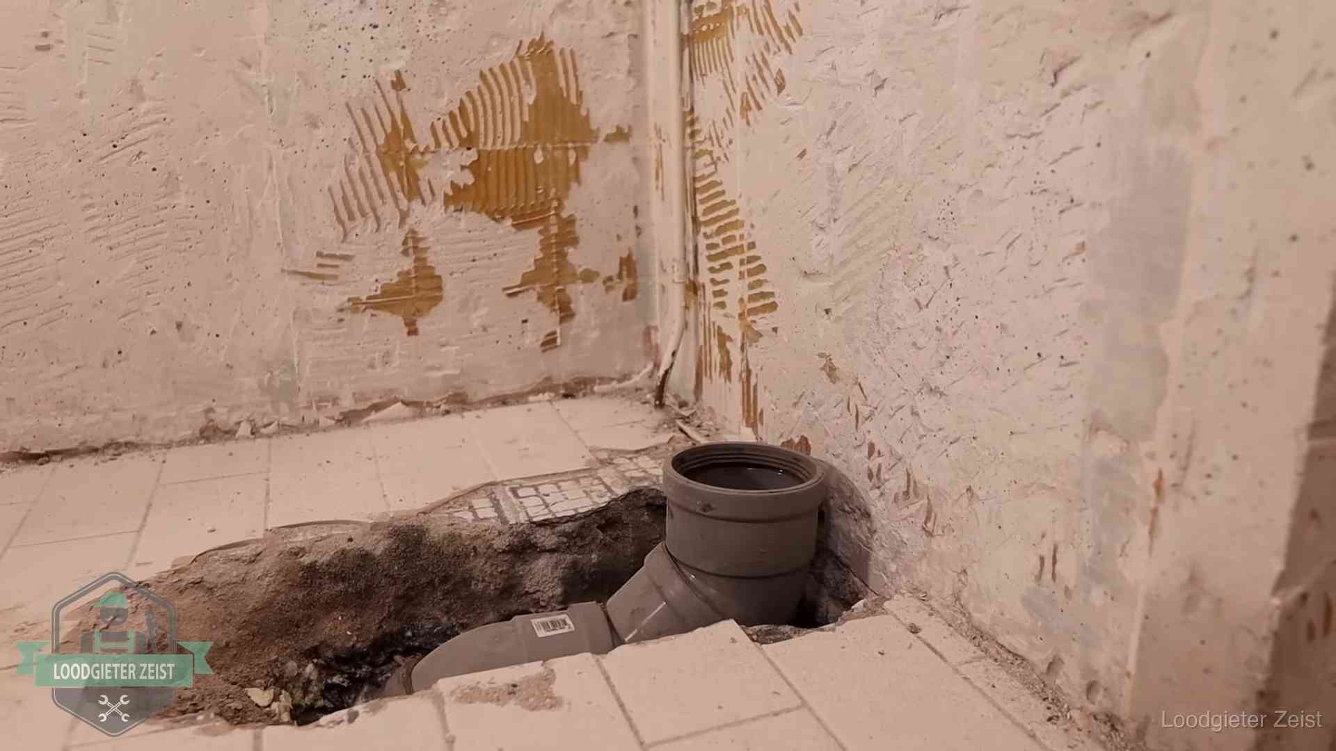Opengebroken vloer met een nieuwe pvc-rioolbocht in een gegraven sleuf in Zeist