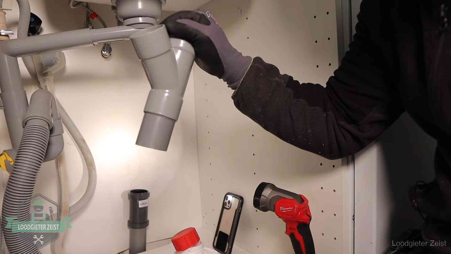 Loodgieter demonteert het sifon- en afvoerwerk onder een gootsteen in Zeist bij stankklachten