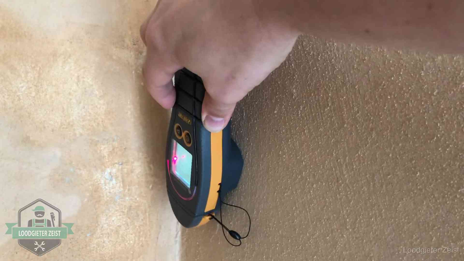 Vochtmeter tegen een muur met vochtplekken tijdens het opsporen van een daklekkage in Zeist